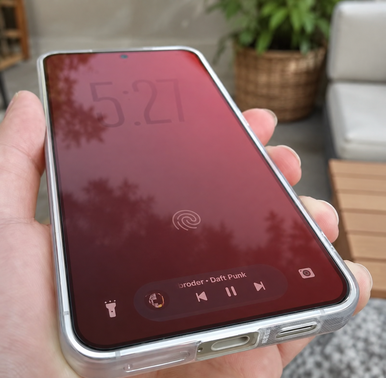 Samsung Galaxy S24 in de hand met LumaShield screenprotector en subtiele rode weergave.